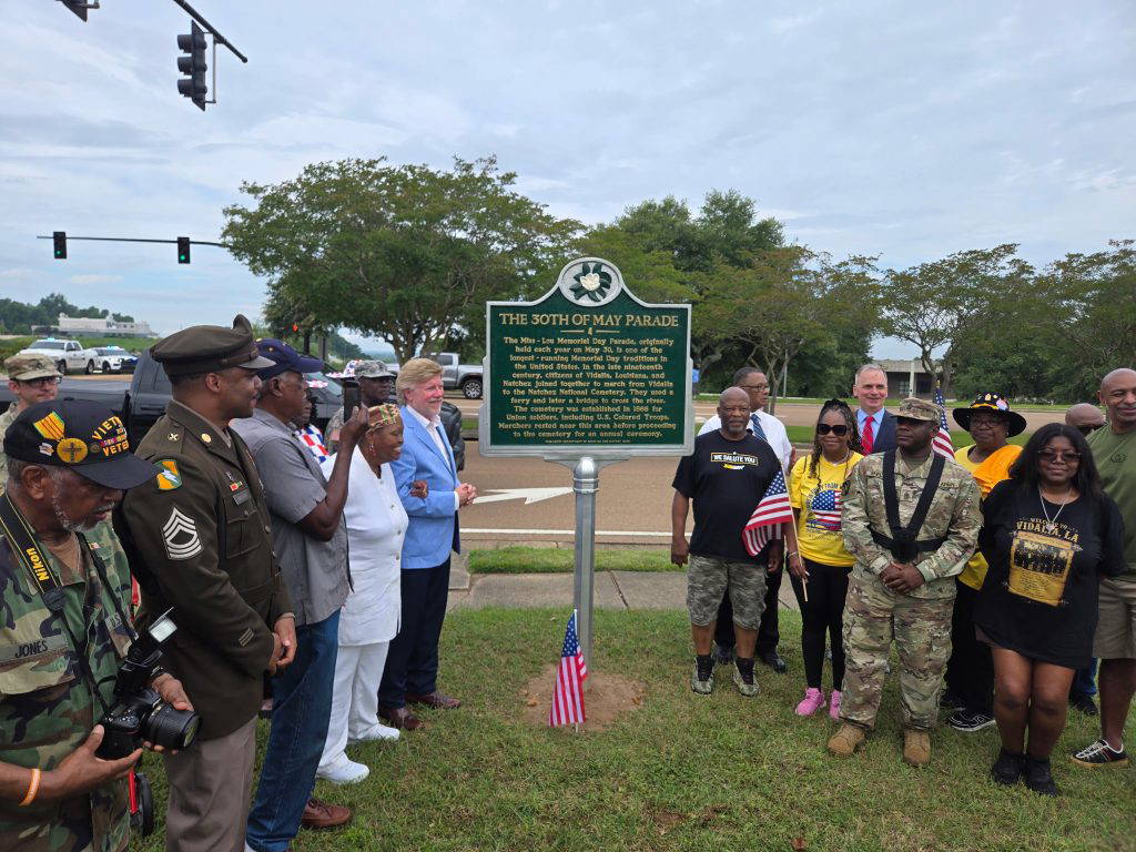 Local officials, veterans, and parade organizers gathered for the unveiling of the new historical marker honoring the Miss-Lou Memorial Day Parade. The marker was dedicated on May 25, 2026, the parade’s 160th anniversary, in front of the Holiday Inn Express in Natchez. (Photo by Michael Wilson / City of Natchez)