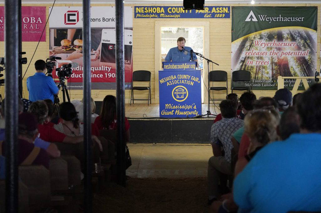 Republican Gov. Tate Reeves addresses the crowd at the pavilion in Founders Square at the Neshoba County Fair in Philadelphia, Miss., Thursday, July 28, 2022. The fair, also known as Mississippi's Giant House Party, is an annual event of agricultural, political, and social entertainment at what might be the country's largest campground fair. (AP Photo/Rogelio V. Solis)
