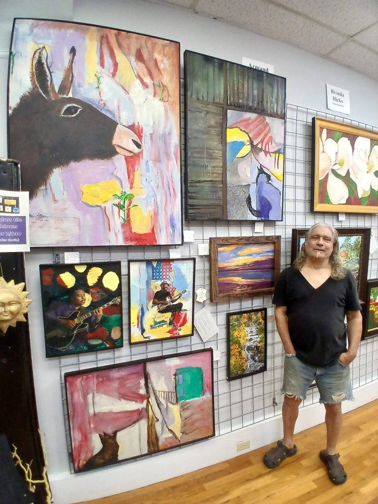 Artist Armand Saiia with his paintings on display at ArtsNatchez Gallery.Photo by Roscoe Barnes III