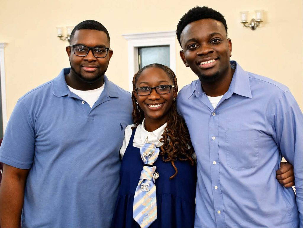 Standing, from left, are siblings Kirk, LaSarah, and Kirklyn Johnson. Twin brothers Kirk and Kirklyn were diagnosed with non-verbal autism at age 3 and relied on music to help develop their speech and learning.
