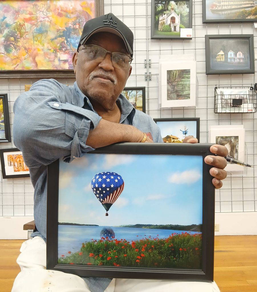ArtsNatchez Gallery Director Leon Hollins showcases Carolyn Terry's "Red, White and Blue" photograph, part of the collection that will be featured Saturday at the downtown gallery.