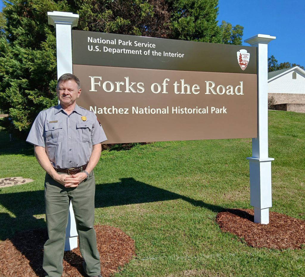 Jeff Mansell, lead historian at Natchez National Historical Park, stands next to the new location sign at the Forks of the Road site.