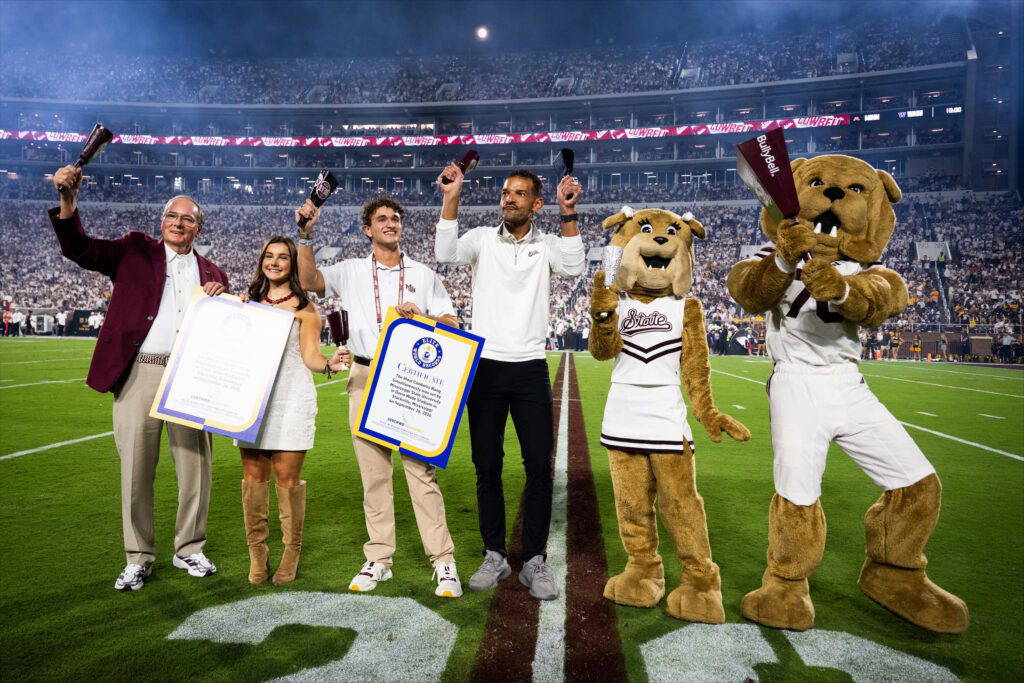 MSU President Mark E. Keenum, from left, MSU Student Association Cowbell Commissioner Miles Jordan, SA President Keegan Figueroa, MSU Director of Athletics Zac Selmon, along with mascots Belle and Bully, celebrate the Bulldogs’ new world record for most cowbells ringing simultaneously at Davis Wade Stadium Sept. 26. (Photo by Grace Cockrell)